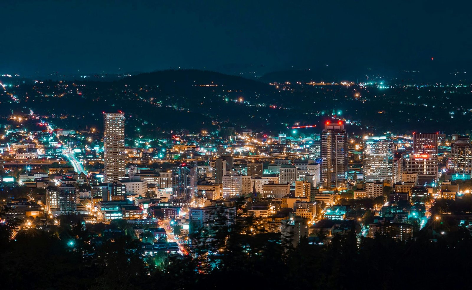 A stunning aerial view of a city skyline illuminated at night, showcasing modern skyscrapers.